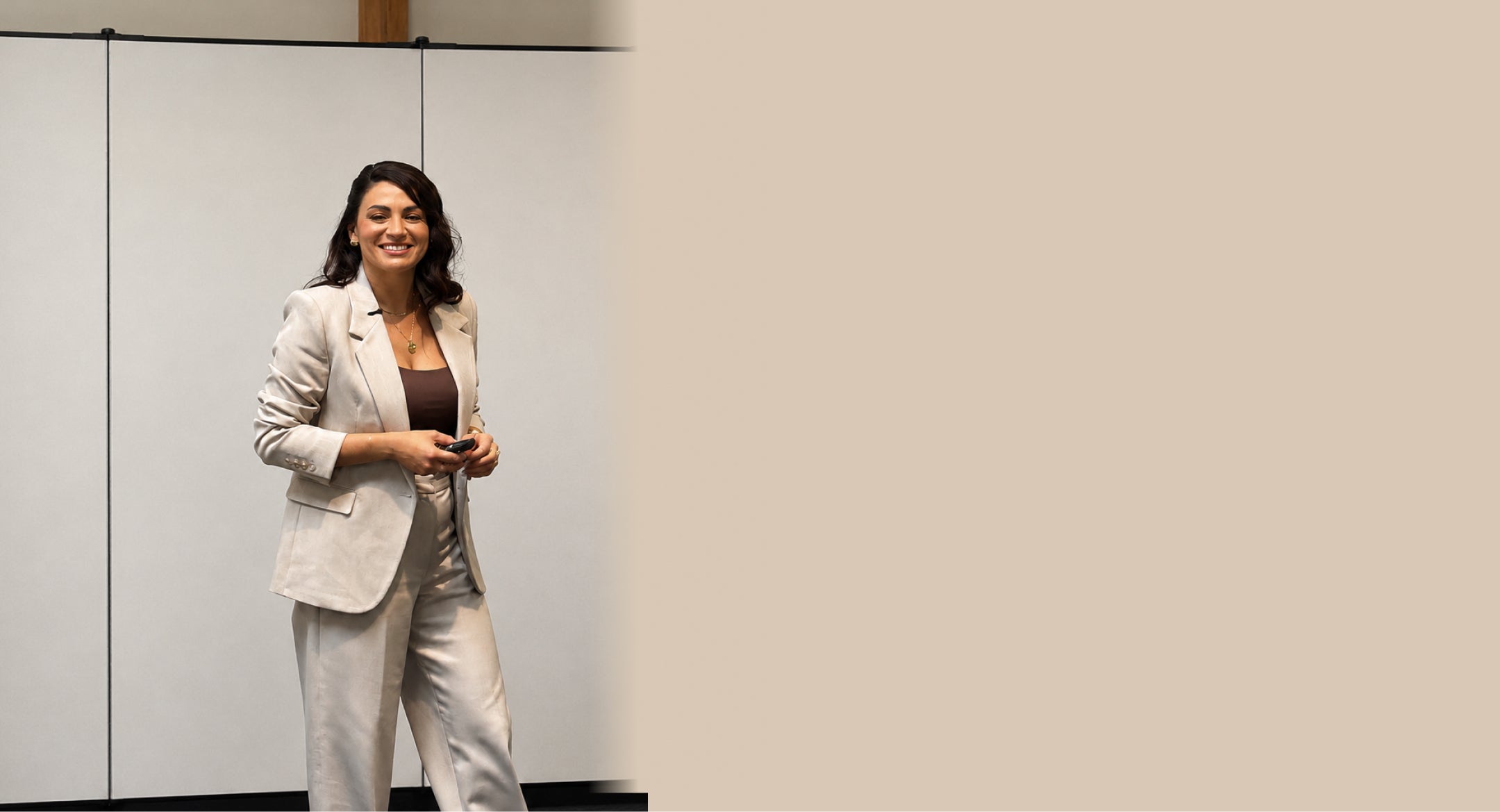 Woman in a light gray suit standing in front of a whiteboard