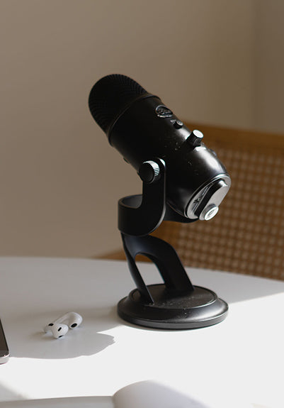 Black microphone on a stand with a blurred background