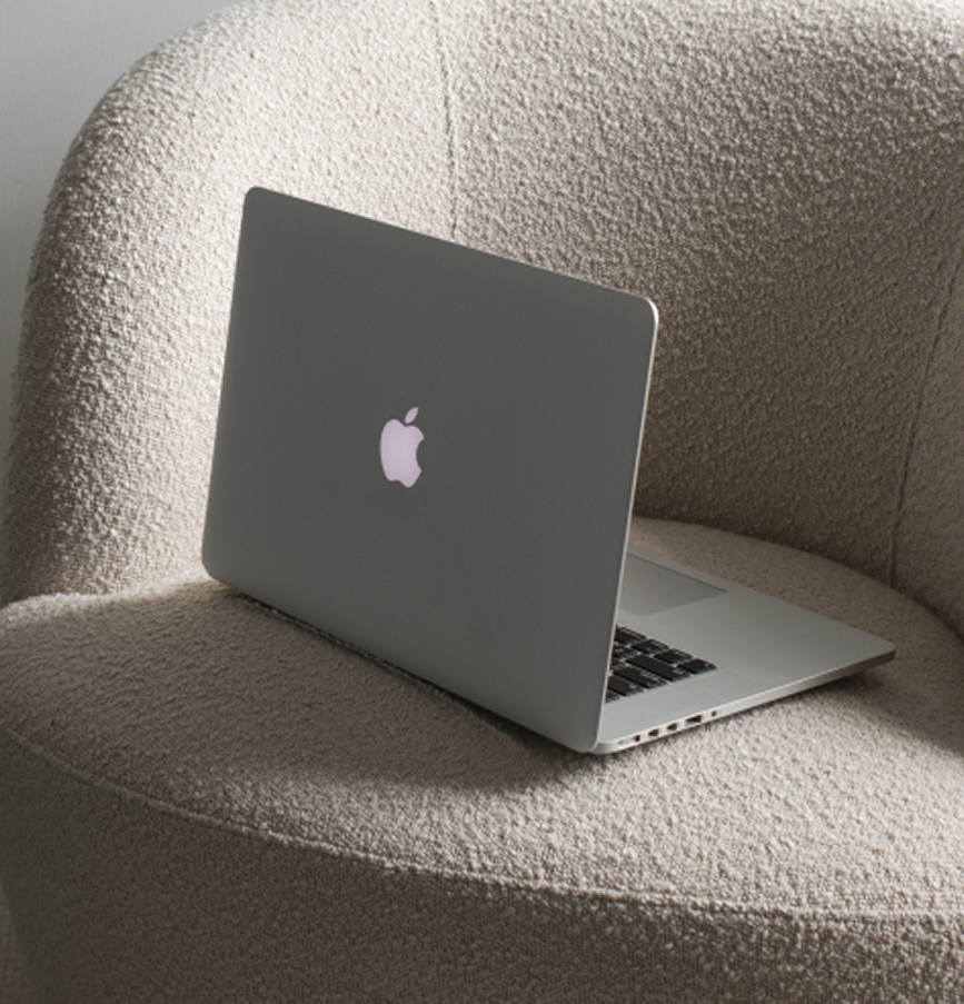 Laptop with Apple logo on a textured beige surface