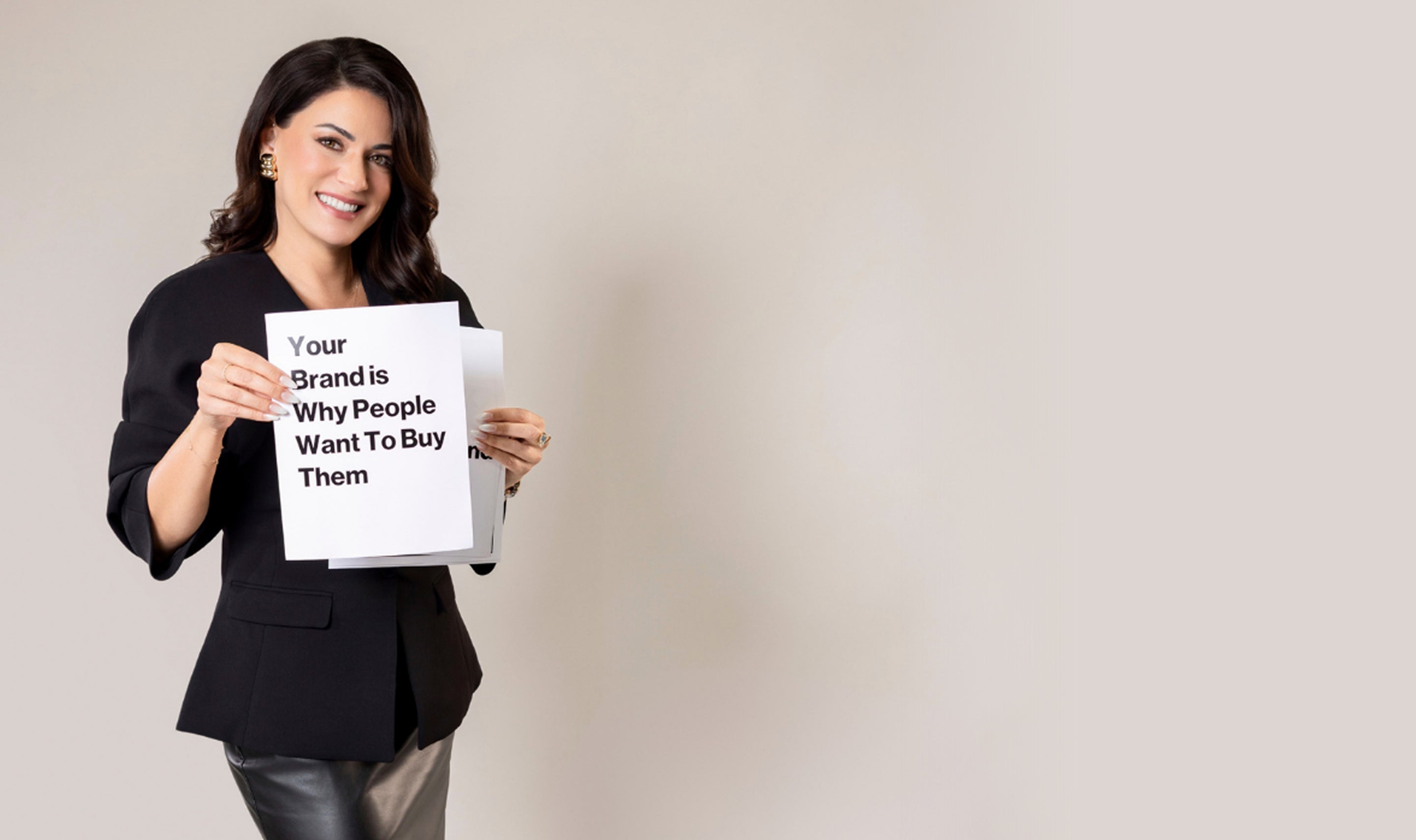 Woman holding a sign with text on a plain background